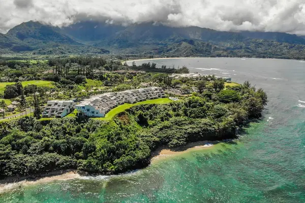 Aerial coastal view reveals turquoise bays, lush grounds, and mountains