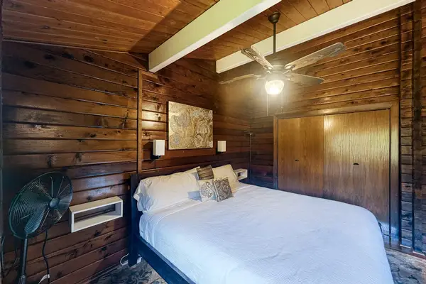 Guest bedroom with a queen bed, ceiling fan and lots of natural light.