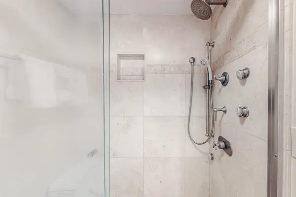 Modern walk-in shower with rain shower head along with a handheld shower head