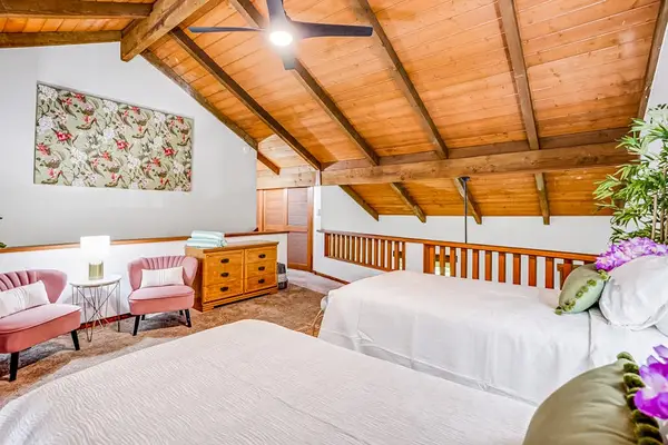 Two twin beds located in the loft with vaulted ceilings.
