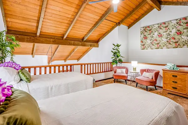 Two twin beds located in the loft with vaulted ceilings.