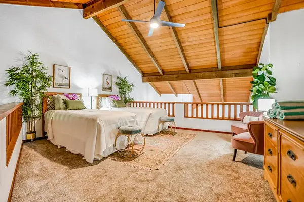 Two twin beds located in the loft with vaulted ceilings.