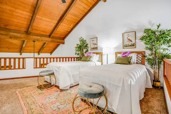 Two twin beds located in the loft with vaulted ceilings.