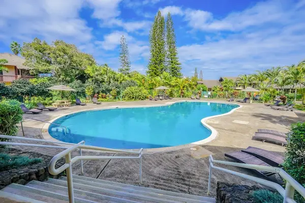 Sparkling resort-style pool surrounded by tropical landscaping