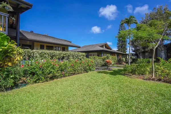 Sunny lawn spreads between tropical gardens and relaxed island homes