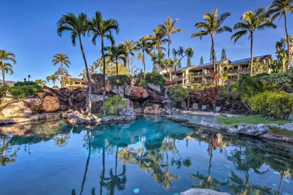 Relax beside peaceful waters surrounded by lush tropical resort landscaping