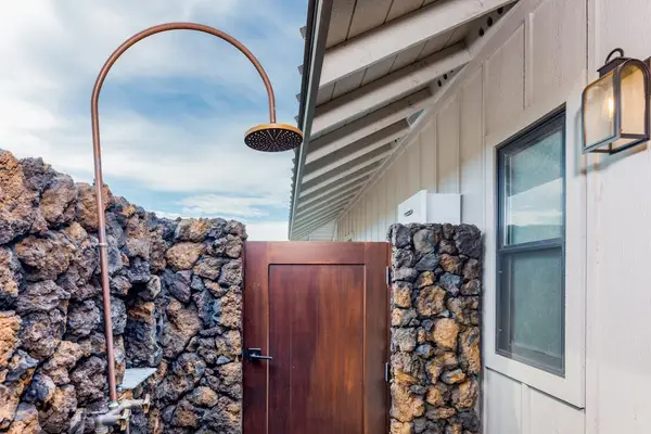 Outdoor Shower Enclosed by Natural Lava Rock Wall & Wooden Gate