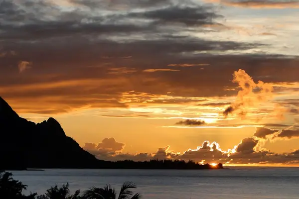 Watch breathtaking sunset colors glow across the peaceful tropical horizon
