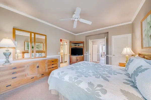 Primary Bedroom View Showing Wooden Dresser, Mirror & En-Suite Access