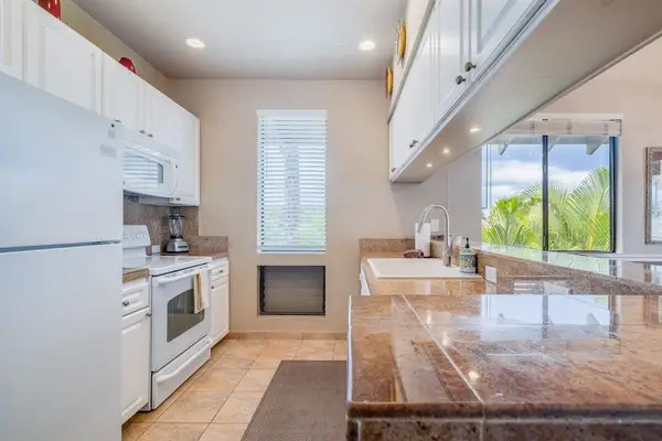Fully Equipped Kitchen with White Appliances, Tile Counters & Breakfast Bar