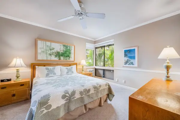 Primary Bedroom Featuring King Bed, Tropical Quilt & Light Wood Furniture