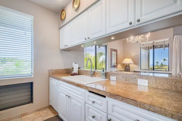 Kitchen Prep Area with Tile Countertops, White Cabinets & Pass-Through