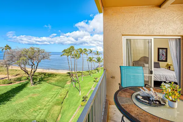 In the evening, dine alfresco as the sun sets over the ocean on your private lanai, featuring an outdoor table.