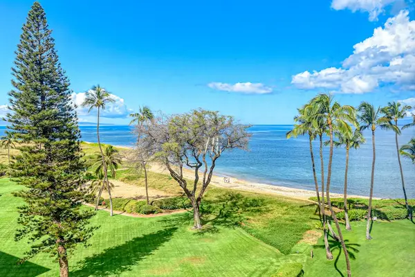 Perfectly manicured lawns with tropical foliage against the backdrop of the Pacific Ocean.