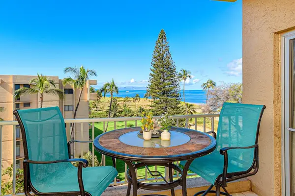 In the evening, dine alfresco as the sun sets over the ocean on your private lanai, featuring an outdoor table.