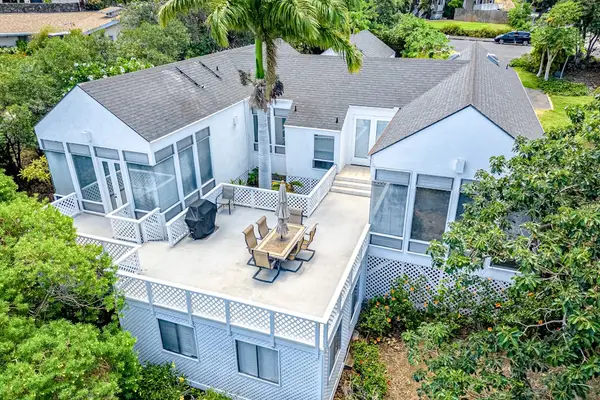 Aerial view showcases beautiful home, spacious balcony, and stunning surrounding natural scenery below