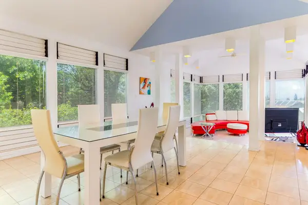 Open dining and living space with floor-to-ceiling glass showcasing beautiful natural surroundings