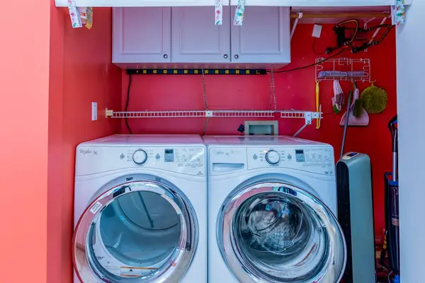 Washer and dryer area includes appliances, shelving, counters, and storage