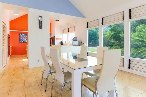 Dining setting features table, chairs, artwork, windows, and open layout