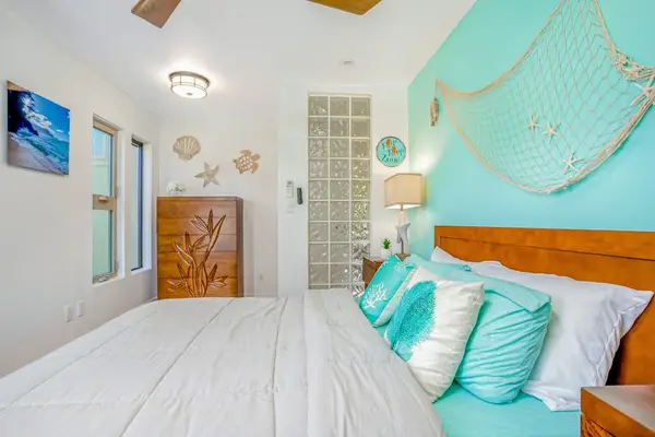 Guest bedroom with queen bed and ceiling fan.