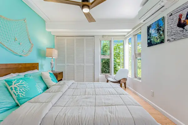 Guest bedroom with queen bed and ceiling fan.