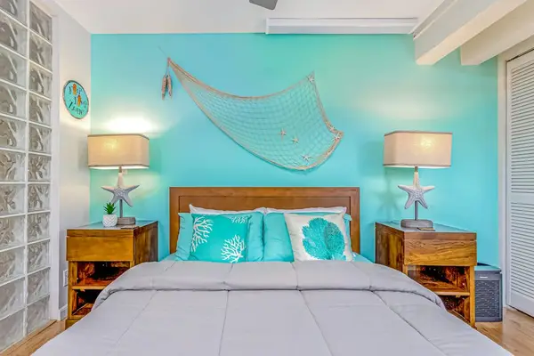 Guest bedroom with queen bed and ceiling fan.