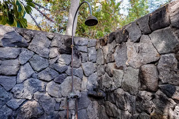 Private Outdoor Rain Shower Enclosed by Custom Natural Stone Walls