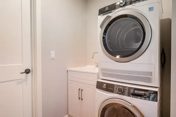 In-Unit Laundry Room with Stacked Washer, Dryer & Utility Sink