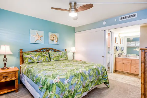 Master bedroom with king bed, ceiling fan, flat screen tv and en-suite bathroom