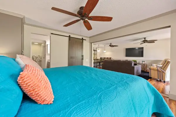 First bedroom connects colorful king bed with open living spaces