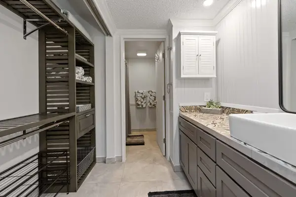 Full bathroom features long vanity bright mirror and walk-in shower