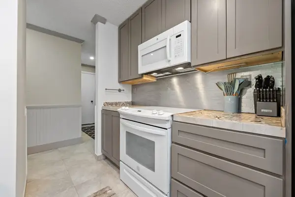 Kitchen peninsula provides ample prep space beneath stylish pendant lighting