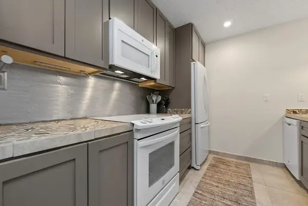 Stainless steel range complements gray cabinetry and streamlined kitchen counters