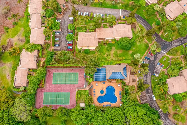 Aerial resort view showcases courts pool buildings and green grounds