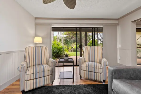 Cozy sitting nook offers two armchairs beside sunny garden windows