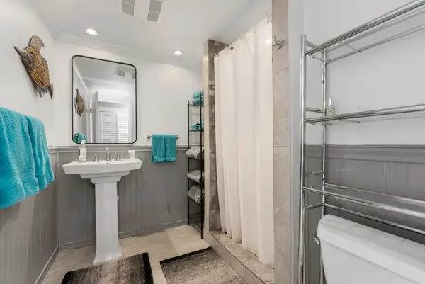 Full bathroom includes glass shower vanity storage and bright finishes