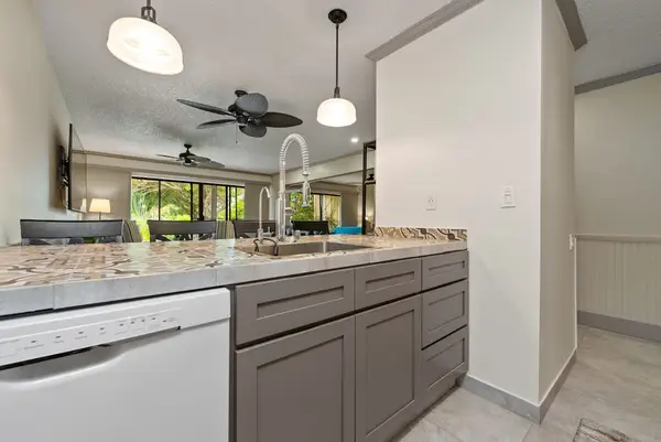 Bright kitchen showcases sink generous counters and modern cabinetry