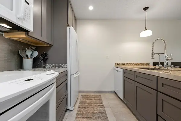 Modern kitchen includes stainless steel range gray cabinetry and counters