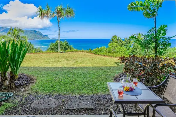 Spacious patio presents outdoor seating beside colorful flowers and greenery