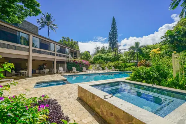 Tropical pool area highlights sparkling water, lush gardens, and sunshine
