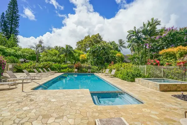 Swimming pool offers cool refreshment beside palms and manicured landscaping