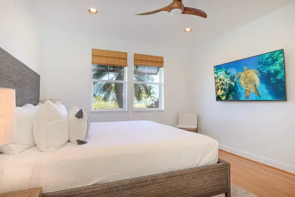 Spacious Primary Bedroom with King Bed and Wall-Mounted Smart TV