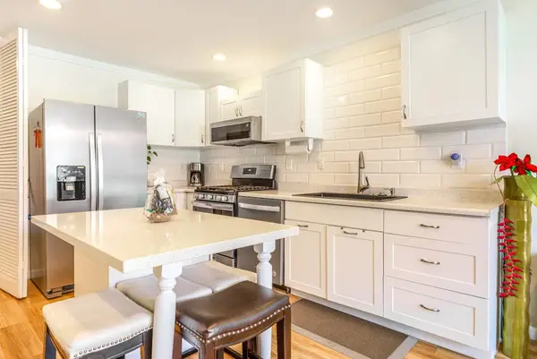 Fully Equipped Modern Kitchen with Island Stools and Stainless Steel Appliances