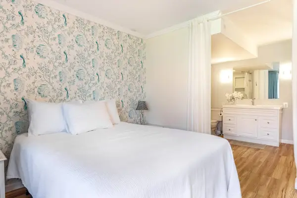 Spacious Bedroom Area with Plush Bedding and Feature Accent Wall
