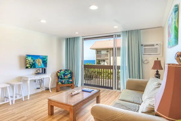 Bright Living Room with Sofa Seating, Smart TV, and Balcony Access