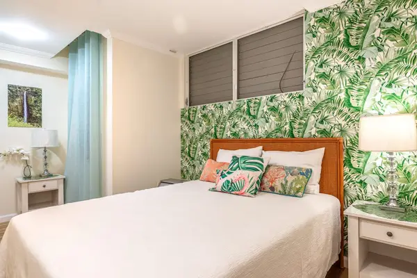 Stylish Bedroom with Botanical Wallpaper, Headboard Accent, and Bedside Storage
