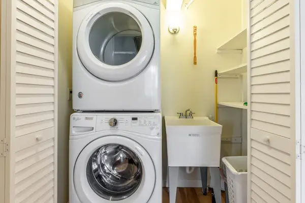 In-Unit Stacked Washer and Dryer with Utility Sink and Closet Storage