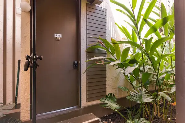 Private Front Entrance Door with Unit Signage & Tropical Greenery