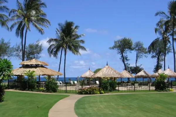 Oceanfront lawn leading to the resort pool and tropical cabanas.