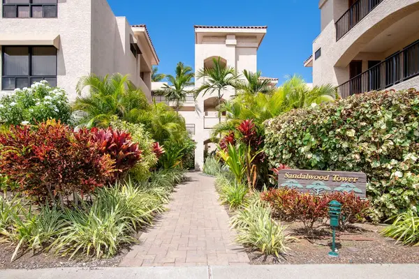 Sandalwood Tower Entrance Walkway Surrounded by Lush Tropical Foliage